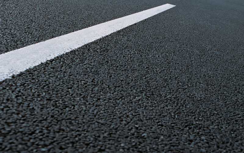 White dotted line on city asphalt road background rollplast asphalt repairer